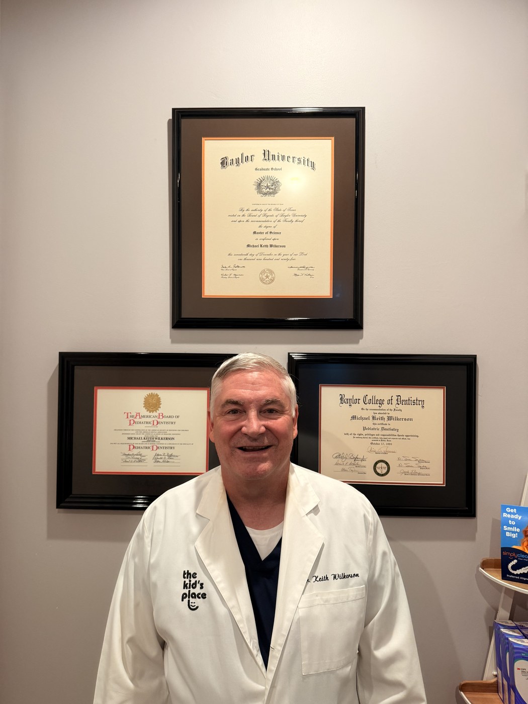 Dr. Keith Wilkerson in his practice, in front of his framed credentials from Baylor University, Baylor College of Dentistry and the American Board of Pediatric Dentistry